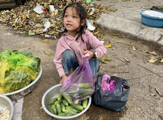 Bé Diệu Anh ra chợ bán rau, phụ bà ở chợ Thái Châu, hôm 17/3. Ảnh: Song Hà