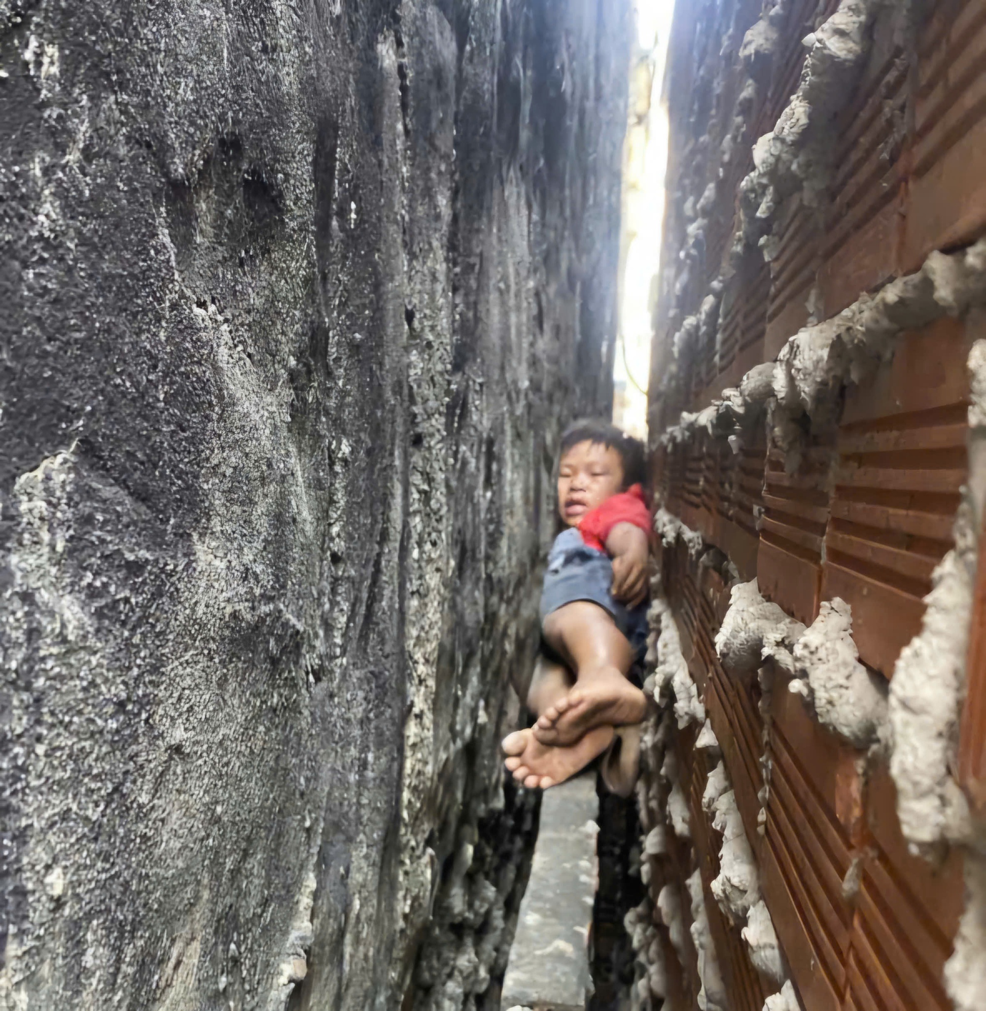 20 phút giải cứu cháu bé bị mắc kẹt giữa hai bức tường nhà ở TPHCM- Ảnh 1. 20 phút giải cứu cháu bé bị mắc kẹt giữa hai bức tường nhà ở TPHCM- Ảnh 1.