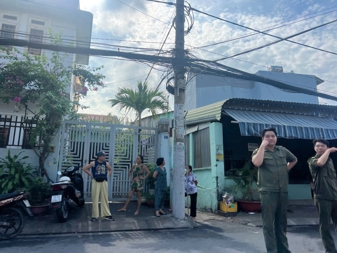 Lực lượng chức năng phong toả lối vào ngôi nhà cháy là hẻm nhỏ rộng chưa đến một mét. Ảnh: Đình Văn