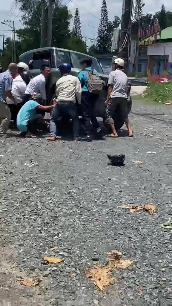 Nhiều người khiêng ôtô cứu nữ sinh mắc kẹt dưới gầm