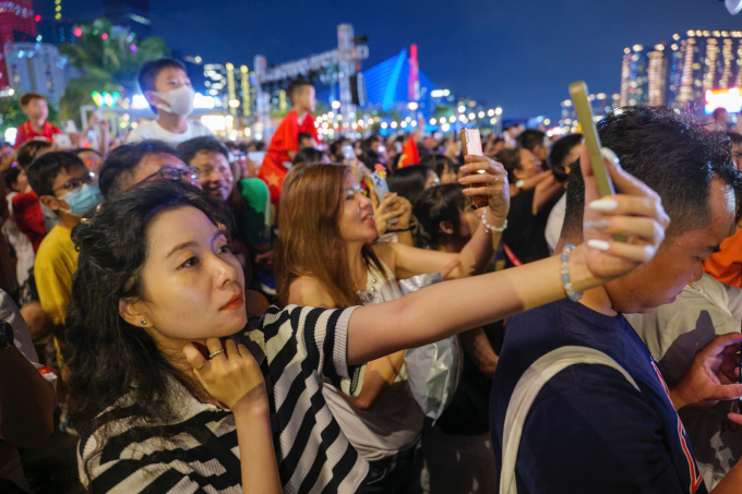 Người dân dùng điện thoại quay phim, chụp hình khoảnh khắc pháo hoa rực sáng trên sông Sài Gòn, tháng 4/2025. Ảnh: Hoàng Việt