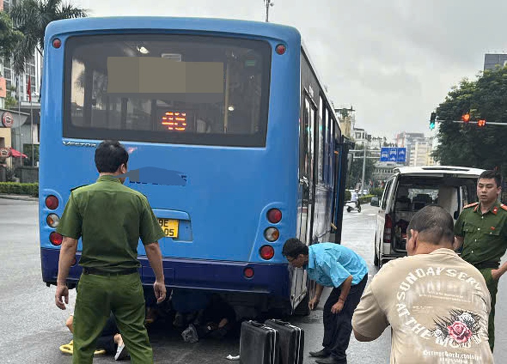 Hơn chục người nâng xe buýt để cứu nữ tài xế xe máy mắc kẹt dưới gầm - 1
