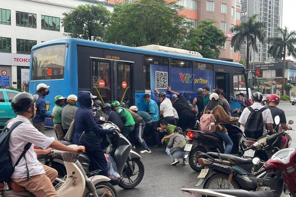 Hơn chục người nâng xe buýt để cứu nữ tài xế xe máy mắc kẹt dưới gầm - 2
